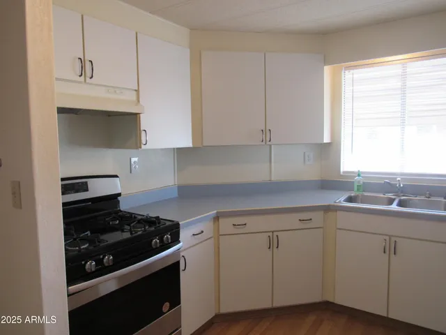 a kitchen with white cabinets and appliances