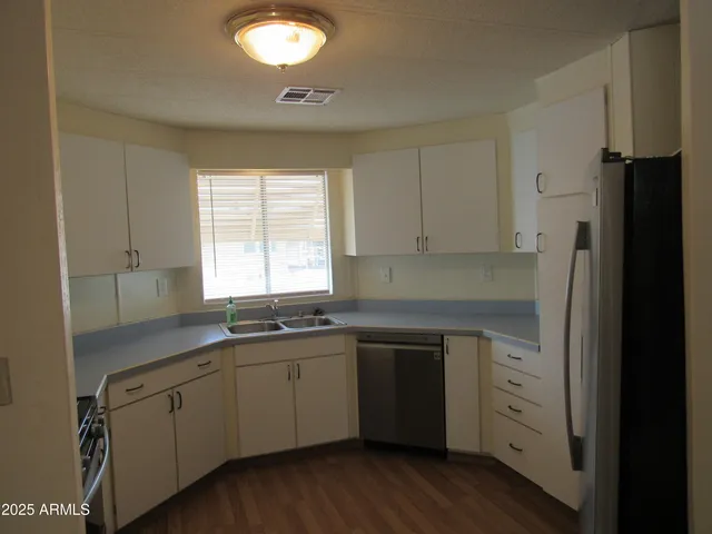 a kitchen with white cabinets and sink