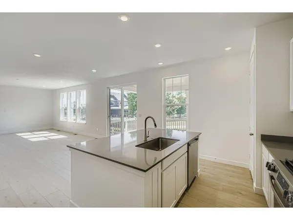 a kitchen with stainless steel appliances granite countertop a sink a stove and a refrigerator