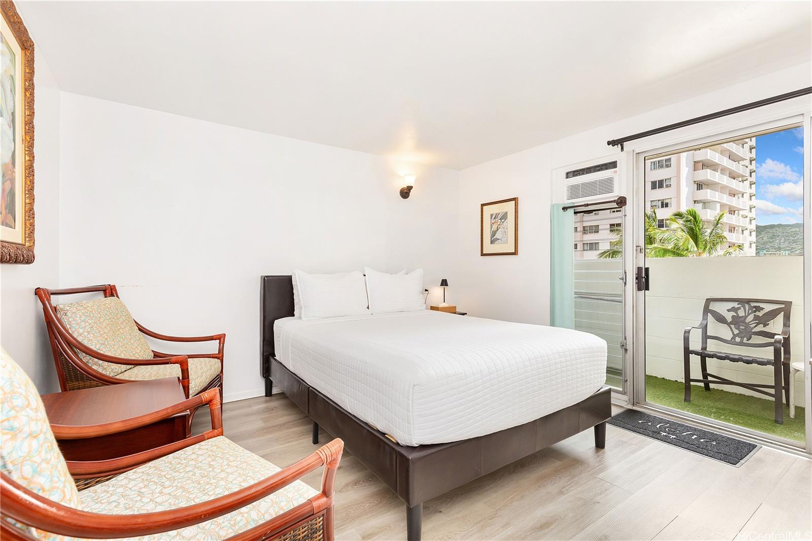 a bed sitting in a bedroom next to a window with chair and lamp