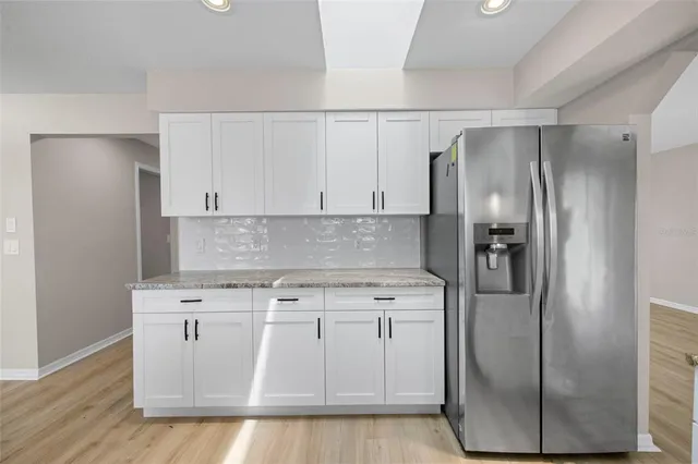 a kitchen with stainless steel appliances granite countertop a refrigerator a stove and a sink