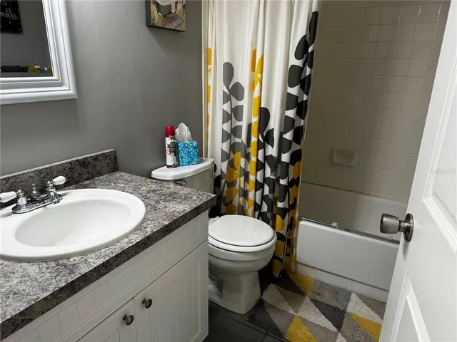 a bathroom with a granite countertop sink toilet and a mirror