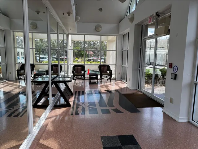 a living room with hardwood floor and large windows
