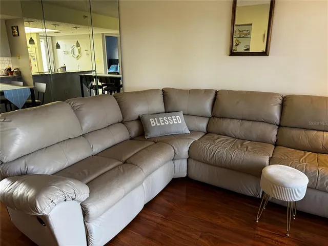 a living room with furniture and wooden floor