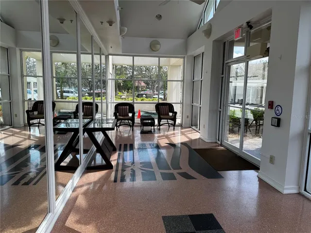 a living room with hardwood floor and large windows