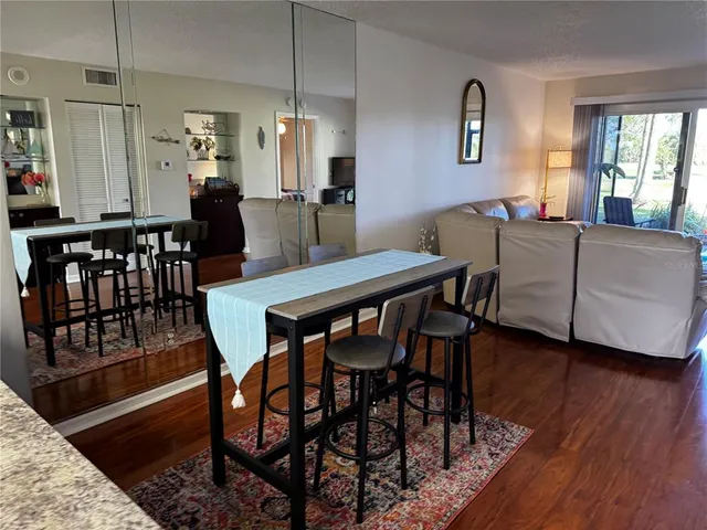 a view of a a dining room with furniture window and wooden floor