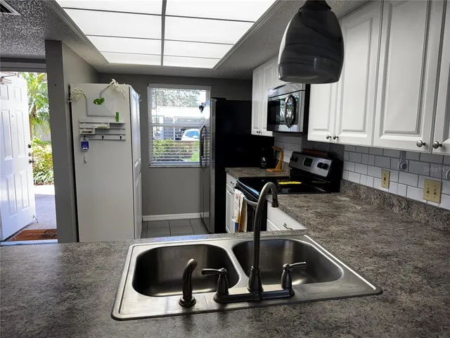 a kitchen with a sink a counter top space cabinets and stainless steel appliances
