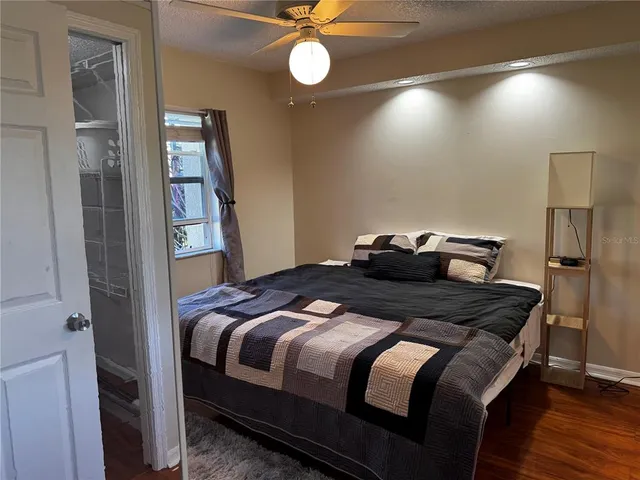 a bedroom with a bed and a ceiling fan