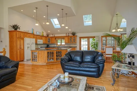 a living room with furniture kitchen view and a large window