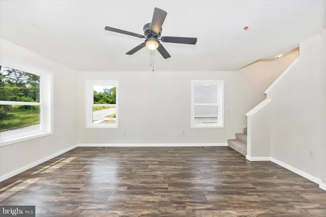 a view of empty room with wooden floor and window