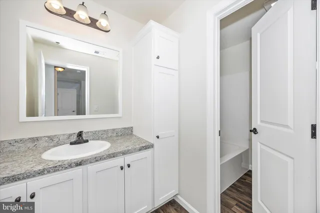 a bathroom with a granite countertop sink and a mirror