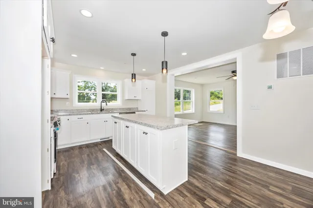 a kitchen with counter top space and wooden floor