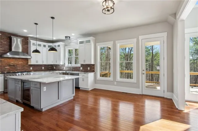 a large kitchen with granite countertop a stove and a wooden floors
