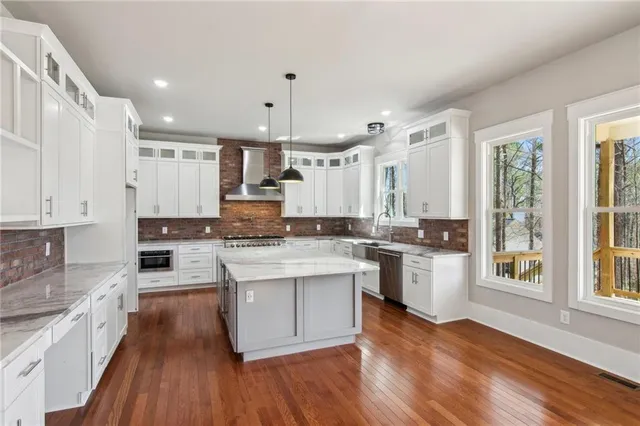 a large kitchen with cabinets wooden floor and stainless steel appliances