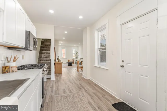 a kitchen with stainless steel appliances granite countertop a refrigerator a sink dishwasher and a stove with wooden floor