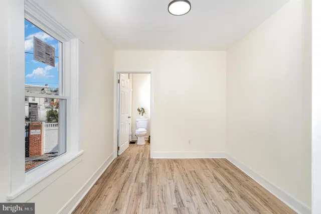 a view of a room with wooden floor and a window