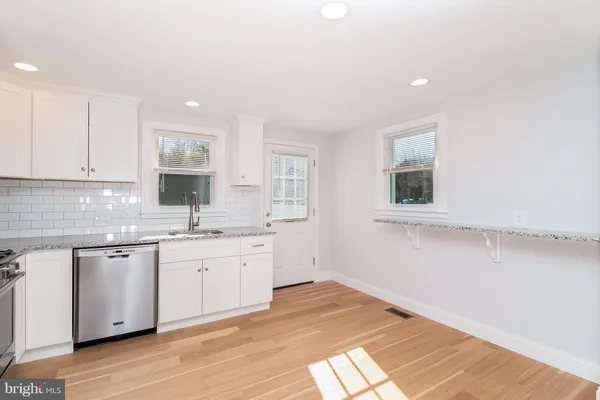 a kitchen with granite countertop white cabinets and white appliances