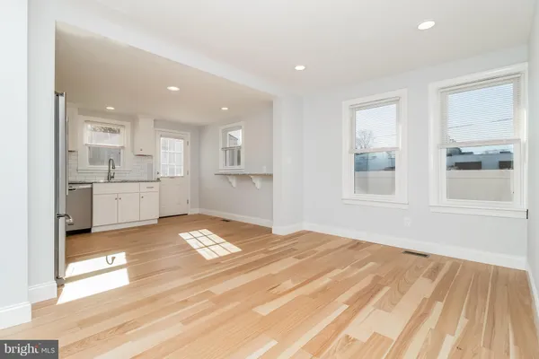 a view of a white house with a large tree