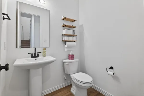 a bathroom with a sink toilet and a mirror