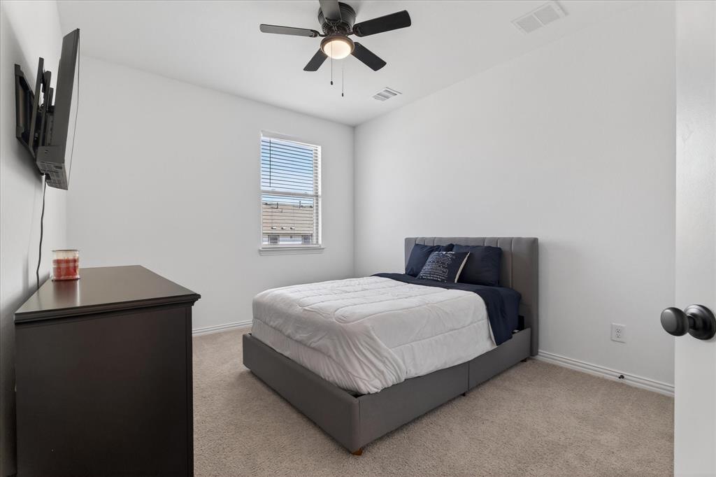 3038 Opera Way Sachse, TX 75048 - Photo 17 of 31 a bedroom with a bed and a flat tv screen on the dresser