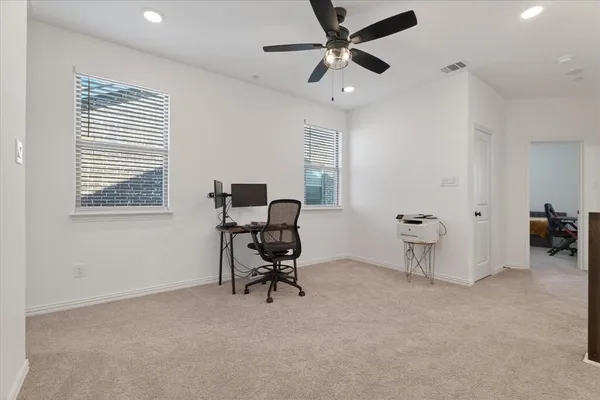 a view of a workspace with furniture and a window