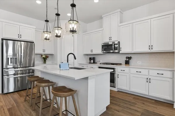 a kitchen with stainless steel appliances granite countertop a sink and a refrigerator