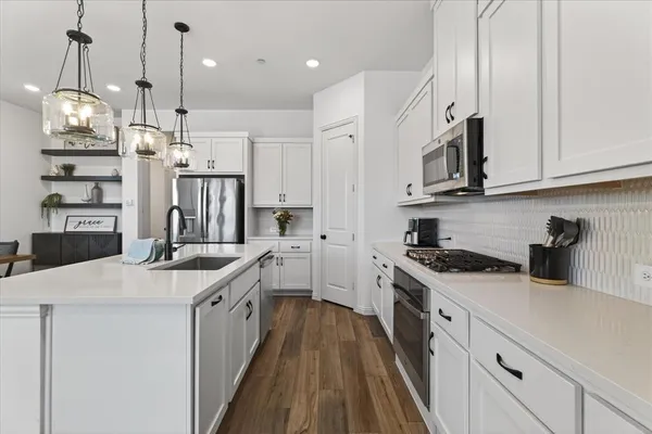 a kitchen with stainless steel appliances granite countertop a sink a stove and a refrigerator