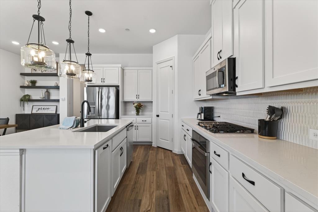 3038 Opera Way Sachse, TX 75048 - Photo 8 of 31 a kitchen with stainless steel appliances granite countertop a sink a stove and a refrigerator