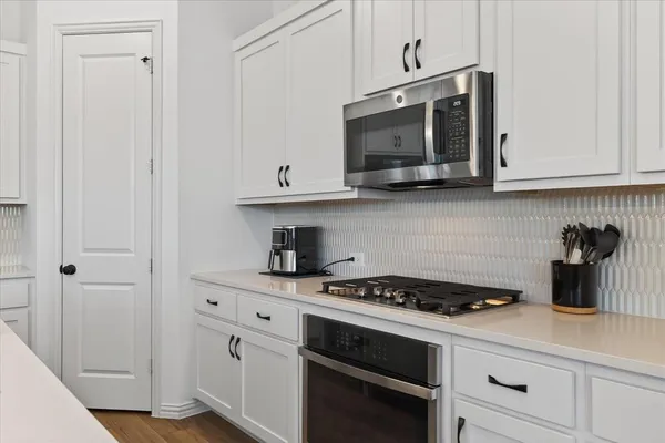 a kitchen with stainless steel appliances a stove a microwave and cabinets