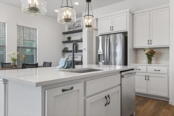 a kitchen with stainless steel appliances a sink and a refrigerator