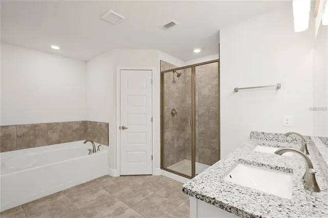 a bathroom with a granite countertop sink a mirror shower and bathtub