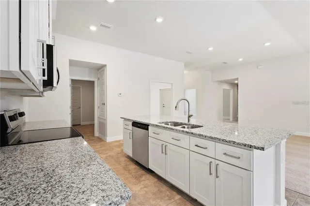 a kitchen with stainless steel appliances granite countertop a sink and a stove