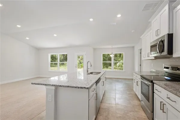 a kitchen with stainless steel appliances granite countertop a sink stove and cabinets