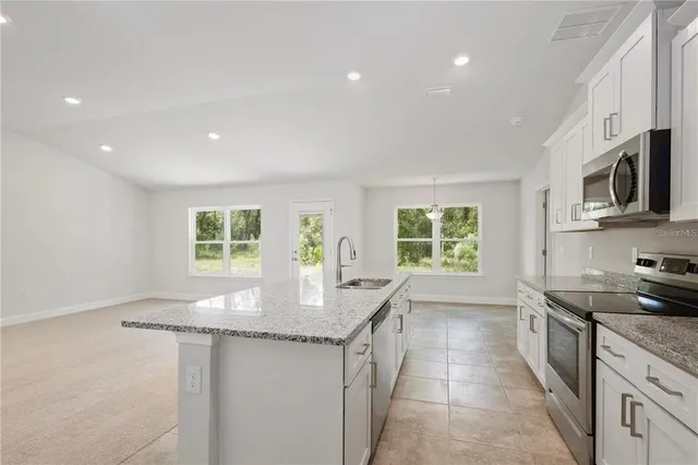 a kitchen with stainless steel appliances granite countertop a sink stove and cabinets
