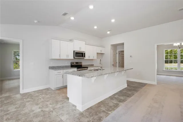 a view of kitchen with stainless steel appliances cabinets