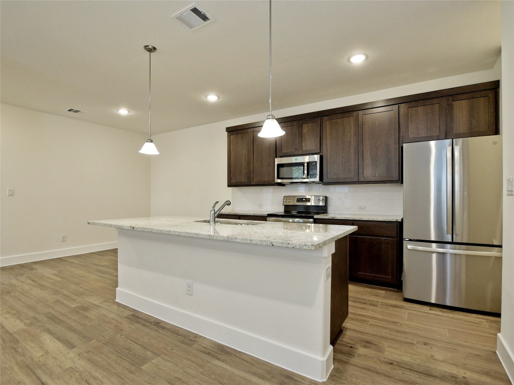 402 Parkline Drive, Unit 24A Georgetown, TX 78626 - Photo 11 of 27 a kitchen with kitchen island a sink stainless steel appliances and wooden floor