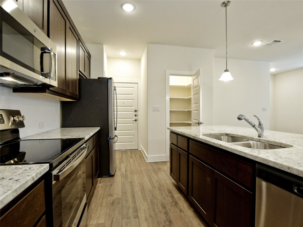 402 Parkline Drive, Unit 24A Georgetown, TX 78626 - Photo 12 of 27 a kitchen with stainless steel appliances granite countertop a sink a stove and a refrigerator