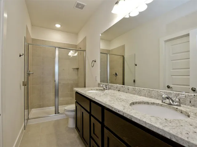 a bathroom with a granite countertop sink a large mirror and a shower