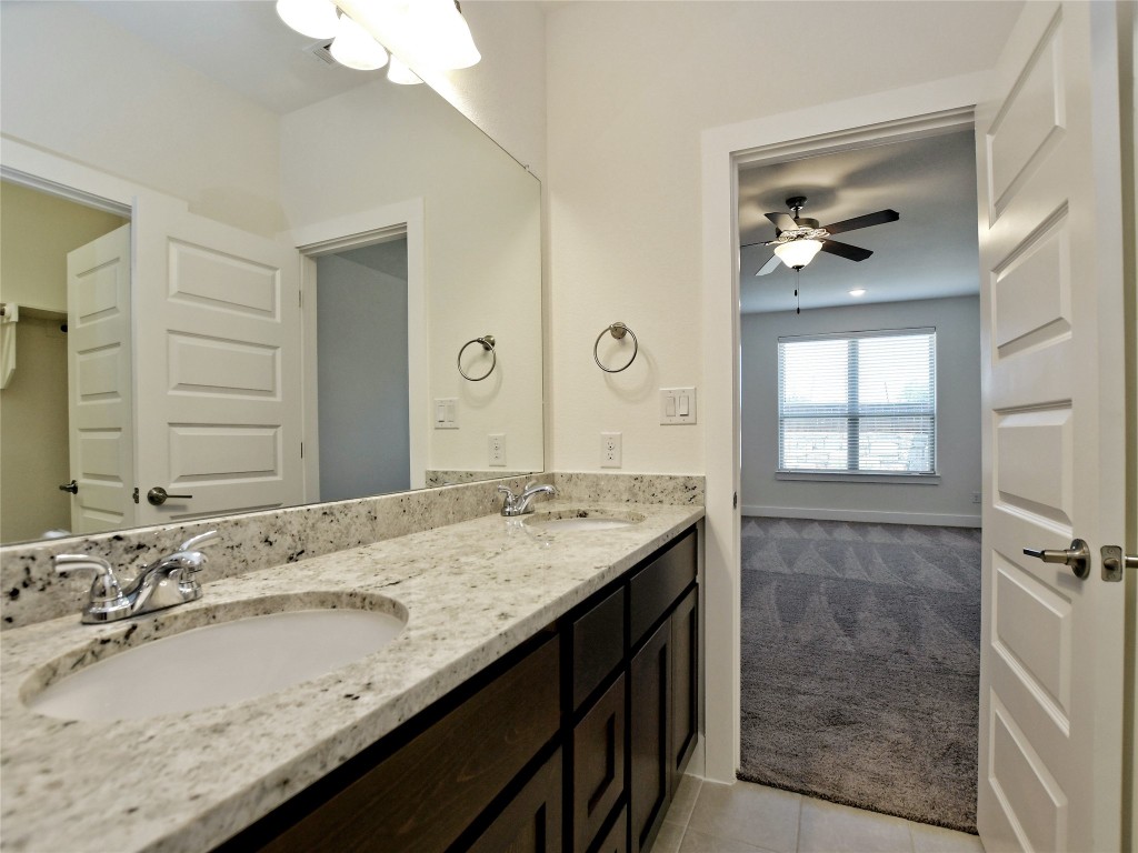 402 Parkline Drive, Unit 24A Georgetown, TX 78626 - Photo 21 of 27 a bathroom with a granite countertop sink a large mirror and a shower