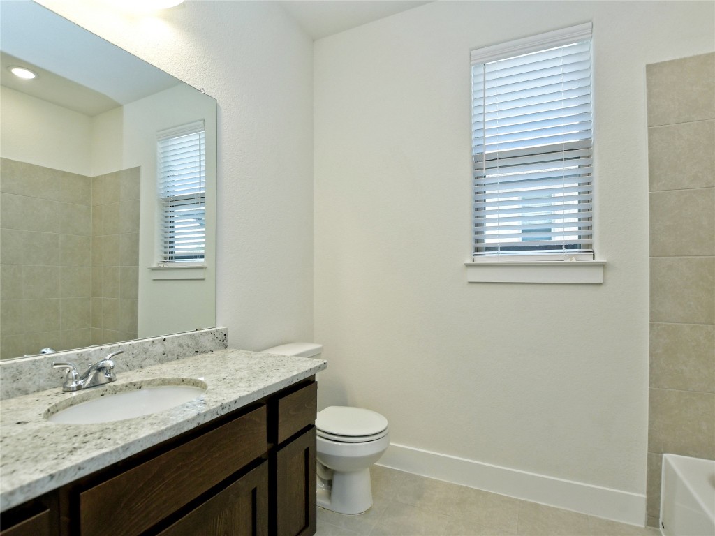 402 Parkline Drive, Unit 24A Georgetown, TX 78626 - Photo 23 of 27 a bathroom with a granite countertop sink toilet and mirror
