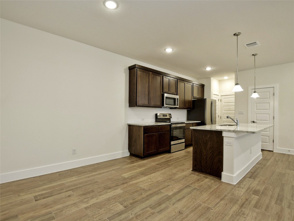 402 Parkline Drive, Unit 24A Georgetown, TX 78626 - Photo 10 of 27 a large kitchen with a center island and wooden floor