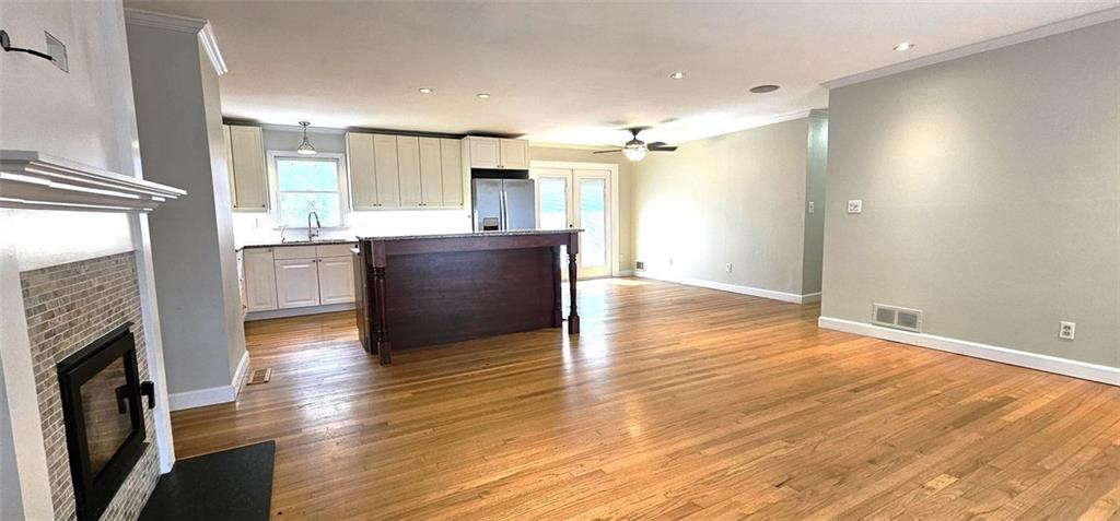 an empty room with wooden floor and a fireplace
