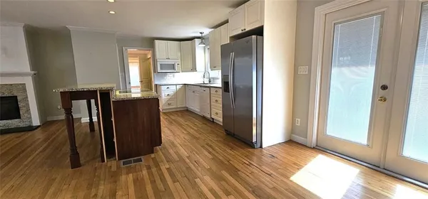 a view of a kitchen with wooden floor and a refrigerator