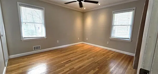 a view of an empty room and window and wooden floor
