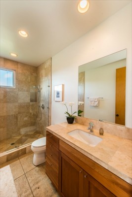 7561 Koolau Road, Unit B Kilauea, HI 96754 - Photo 15 of 25 a bathroom with a granite countertop sink a toilet a mirror and shower
