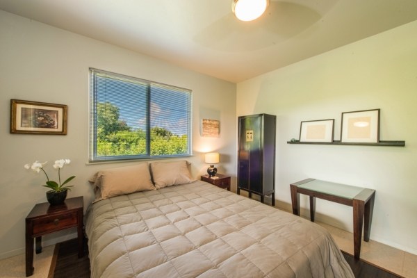 7561 Koolau Road, Unit B Kilauea, HI 96754 - Photo 22 of 25 a bedroom with a bed and a potted plant