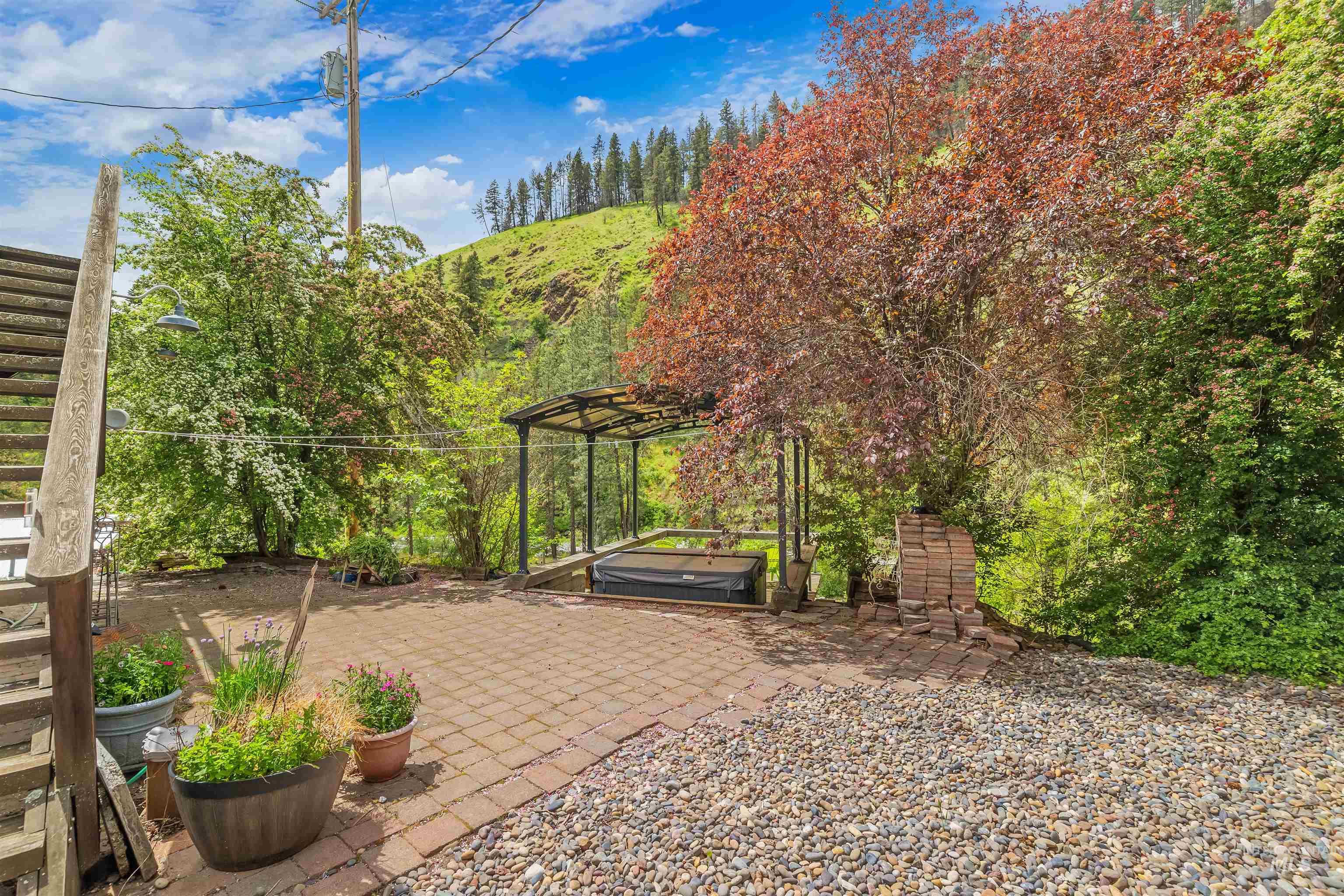 1314 Cedar Ridge Road Kendrick, ID 83537 - Photo 35 of 50 Patio area featuring brick pavers, a gravel section, and a covered hot tub