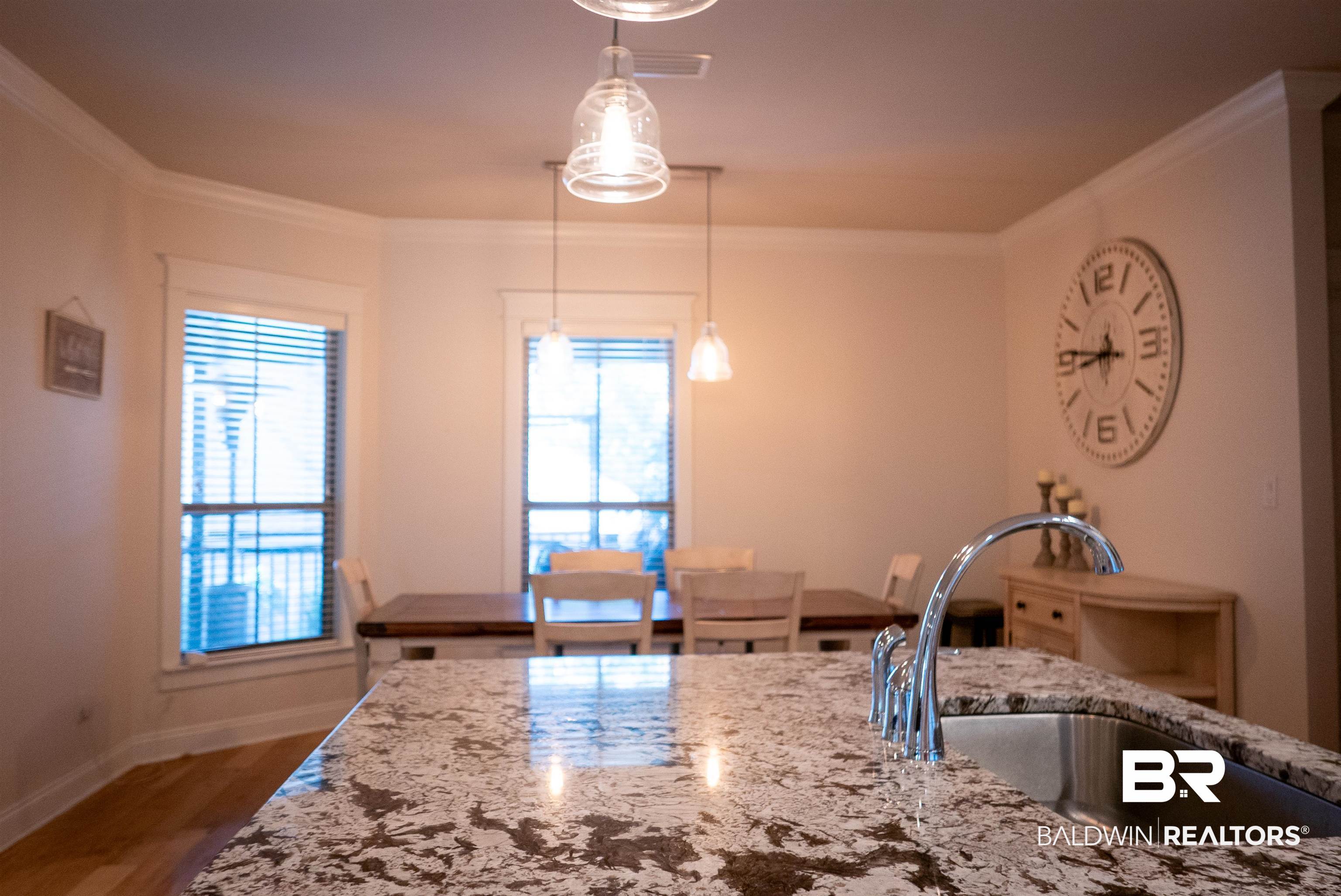6684 Garrison Drive Daphne, AL 36527 - Photo 26 of 35 Kitchen featuring sink, light stone counters, pendant lighting, crown molding, and hardwood / wood-style flooring