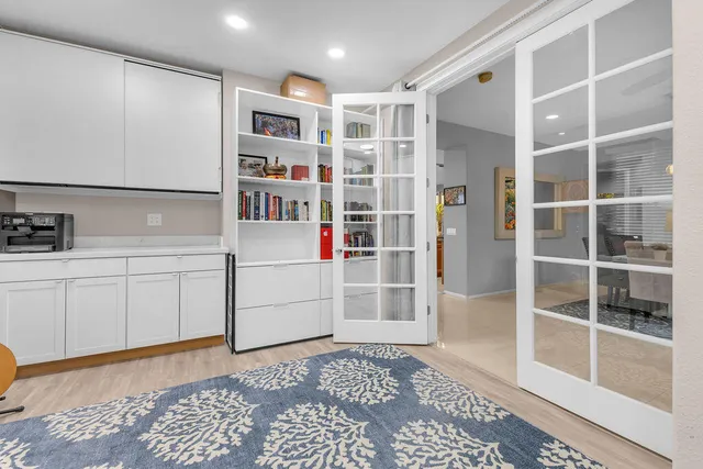 a kitchen with kitchen island granite countertop a white cabinets a stove and a sink
