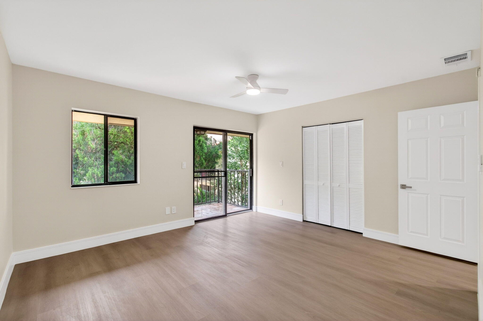 1330 Northwest 13th Street, Unit 12 Boca Raton, FL 33486 - Photo 25 of 52 a view of an empty room with wooden floor and a window